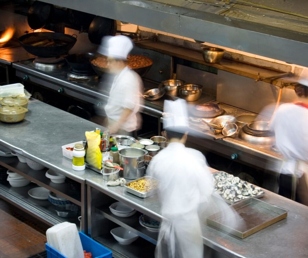 Busy restaurant kitchen during rush hour with staff moving quickly and operational pressure