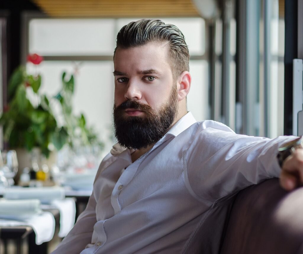 Restaurant owner sitting in his dining area looking concerned about declining profits and business performance